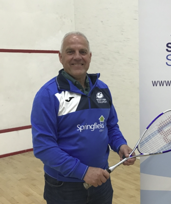 An image of David Taylor standing on a squash court promoting a junior coaching initiative at Forres Squash Club.