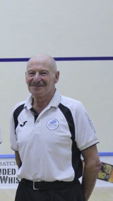 An image of George Tierney standing on a squash court during a prize giving.